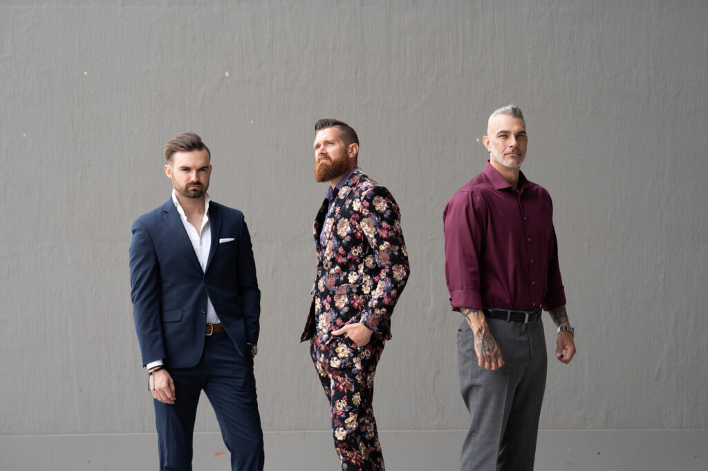 Three well-dressed men standing side by side, promoting the Gentleman’s Assessment for men’s self improvement and personal growth.